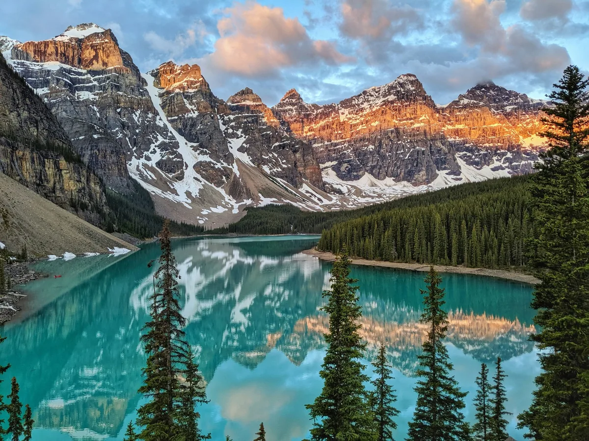 Moraine Lake reflecting the Valley of the Ten Peaks as warm early light reaches the mountain summits