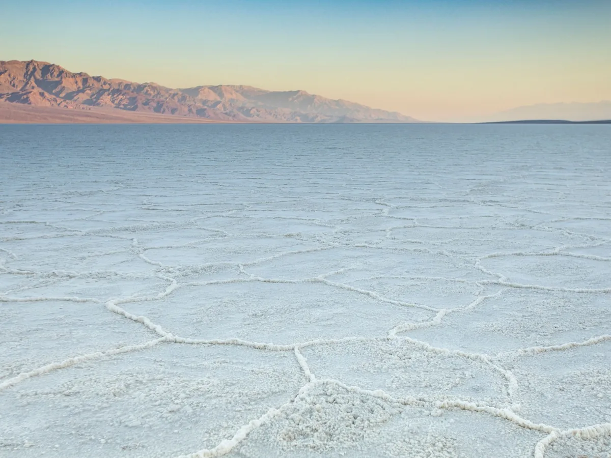Badwater Basin salt polygons stretching across the valley floor toward distant desert mountains