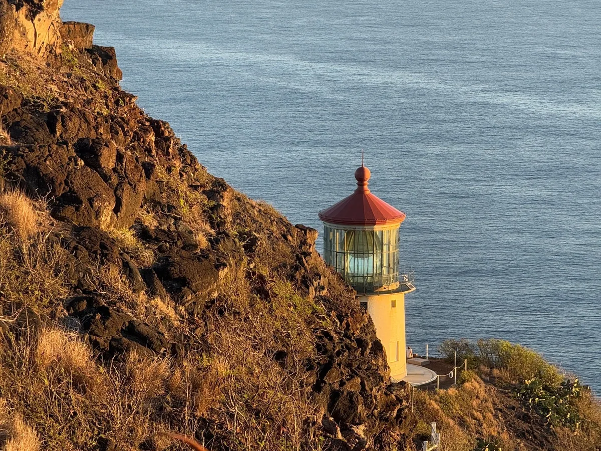 Makapuʻu Lighthouse and rocky windward Oʻahu coastline illuminated by warm directional light