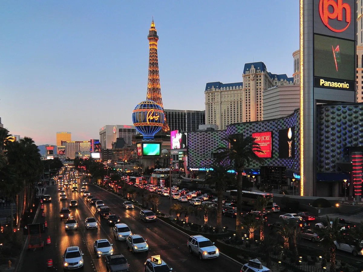 Las Vegas Strip traffic, signs and Paris Las Vegas illuminated during twilight
