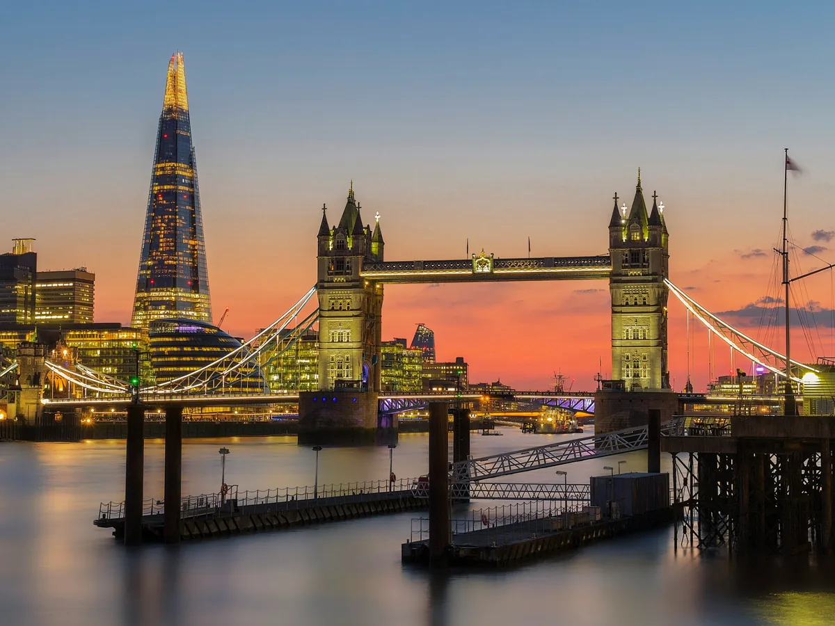 Tower Bridge and the Shard illuminated beside the Thames during sunset-to-blue-hour twilight
