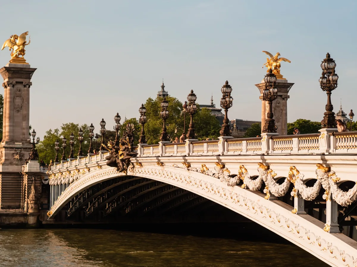 Pont Alexandre III with gilded sculptures and ornate lamps illuminated by warm sunlight