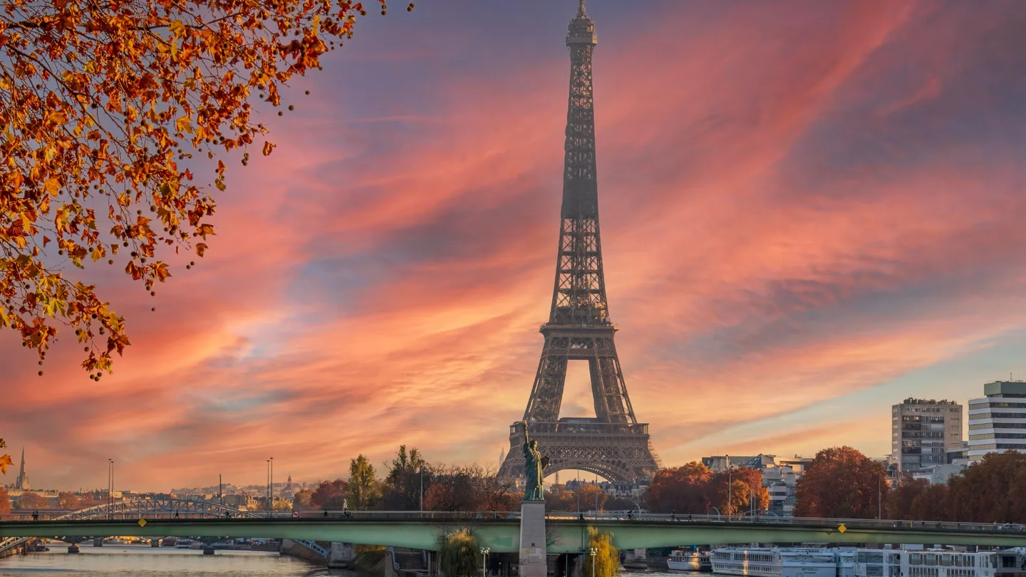 Eiffel Tower and Seine beneath a colorful warm sunset sky in Paris