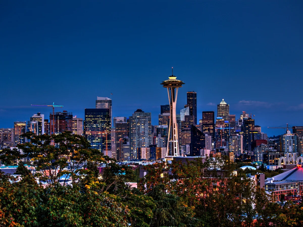 Seattle skyline and illuminated Space Needle beneath a deep cobalt blue-hour sky