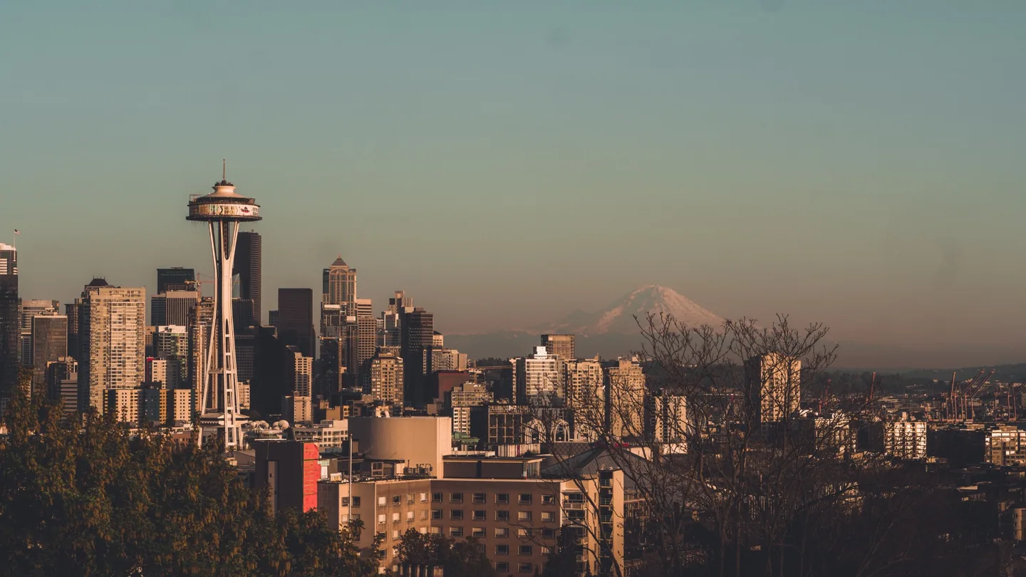 Seattle skyline and Space Needle with Mount Rainier visible in warm clear light