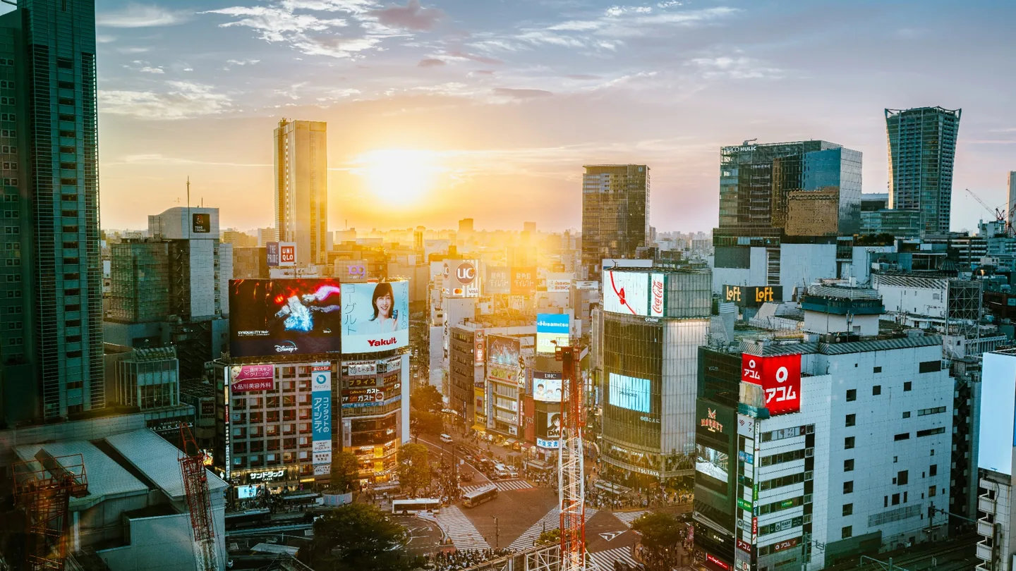 Shibuya skyline and crossing beneath warm sunset light in Tokyo
