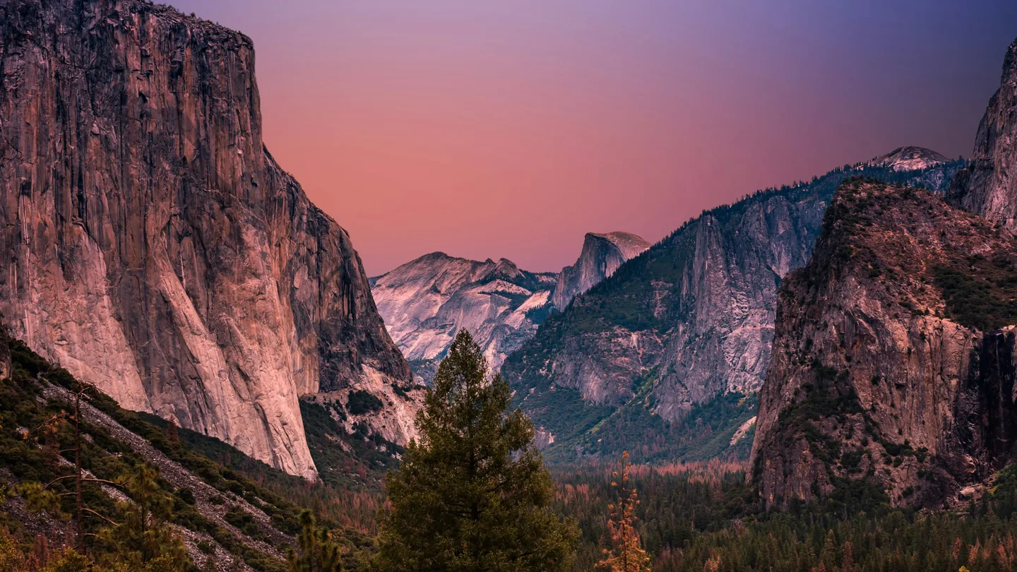 Tunnel View overlooking Yosemite Valley beneath pink and purple evening light